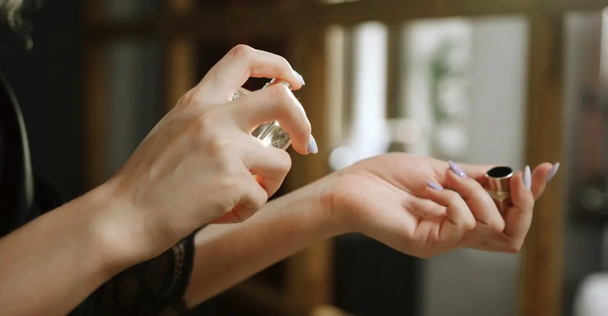 Lady spraying perfume from Luxure Fragrance